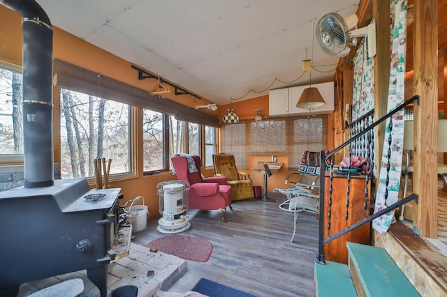 sunroom / solarium featuring a wood stove and rail lighting