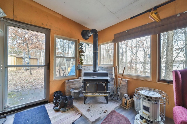 sunroom with a wood stove and vaulted ceiling