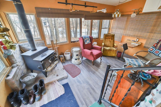 sunroom / solarium featuring a wood stove and plenty of natural light