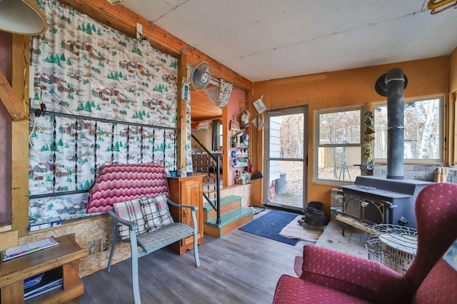 sitting room with a wood stove, stairway, and wood finished floors