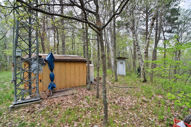 view of yard featuring an outbuilding and a view of trees