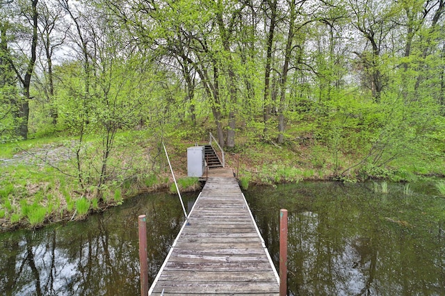 dock area featuring a water view and a wooded view