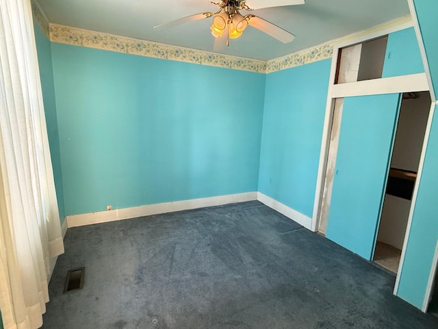 carpeted spare room with baseboards, visible vents, and a ceiling fan