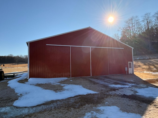 snow covered structure with an outbuilding and an outdoor structure