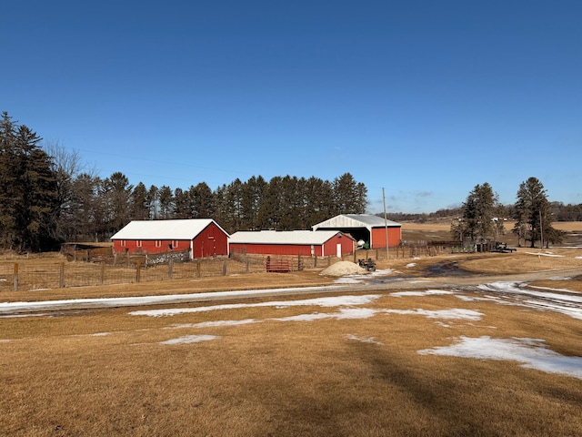 view of yard with an outbuilding, fence, a garage, a pole building, and driveway