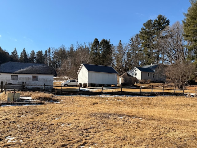 view of yard with a storage unit, fence, and an outdoor structure