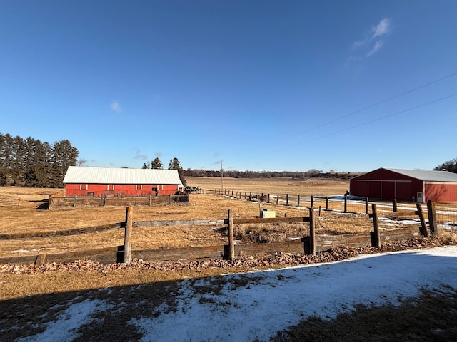 view of yard featuring a rural view, fence, an outdoor structure, and an outbuilding