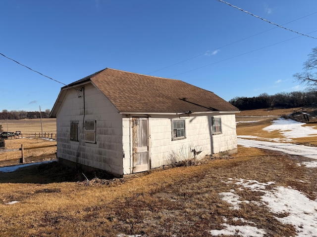 exterior space with roof with shingles