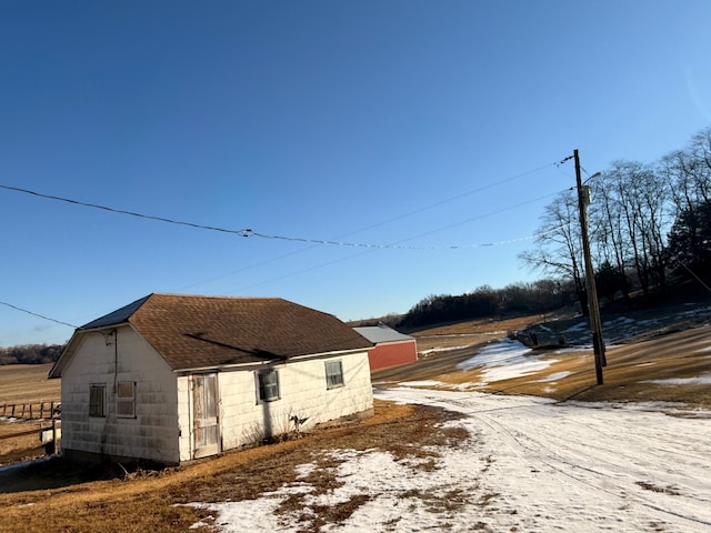 view of side of home featuring roof with shingles