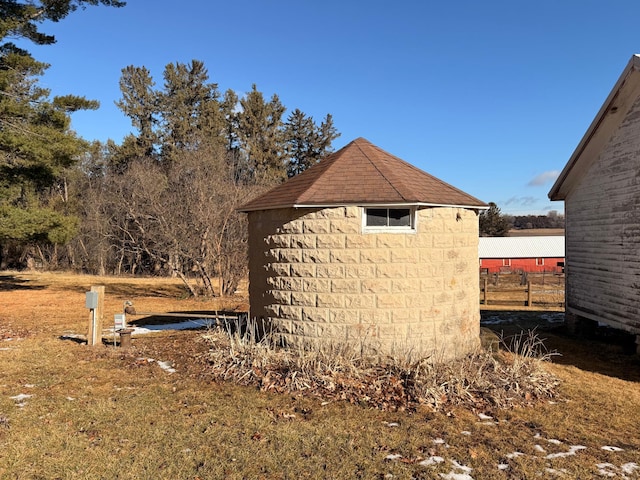 exterior space featuring an outbuilding, a storage shed, and concrete block siding