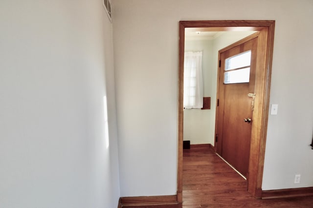 corridor featuring baseboards and wood finished floors