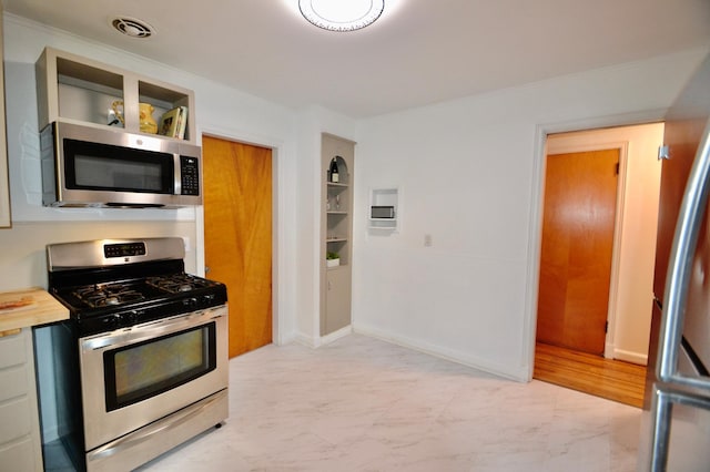 kitchen with visible vents, marble finish floor, appliances with stainless steel finishes, and crown molding