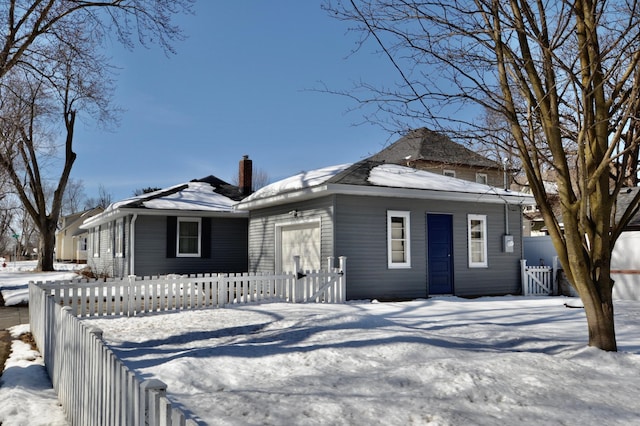 bungalow-style home with a fenced front yard, a chimney, and a gate