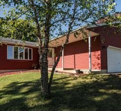 view of side of home featuring an attached garage and a lawn