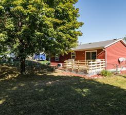 back of property featuring a yard and a wooden deck