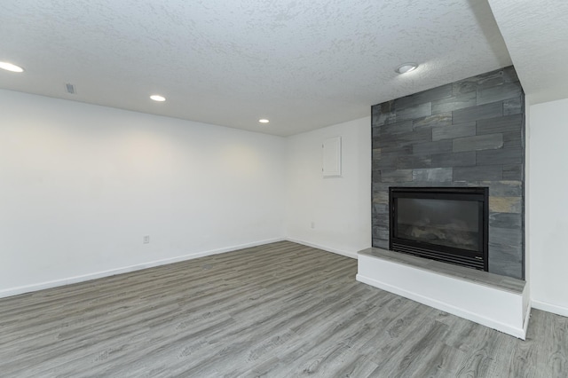 unfurnished living room featuring a fireplace, wood finished floors, and baseboards