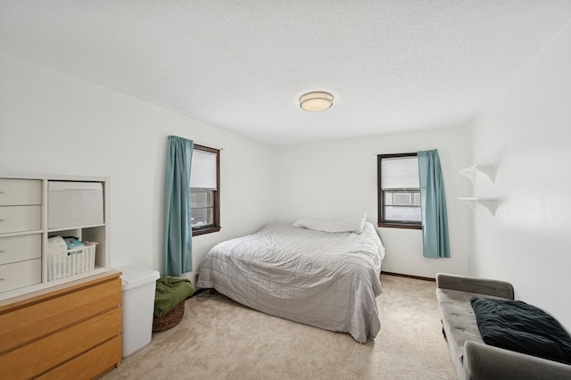 bedroom featuring light carpet and a textured ceiling