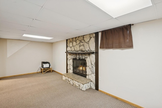 finished basement with carpet floors, a fireplace, a paneled ceiling, and baseboards