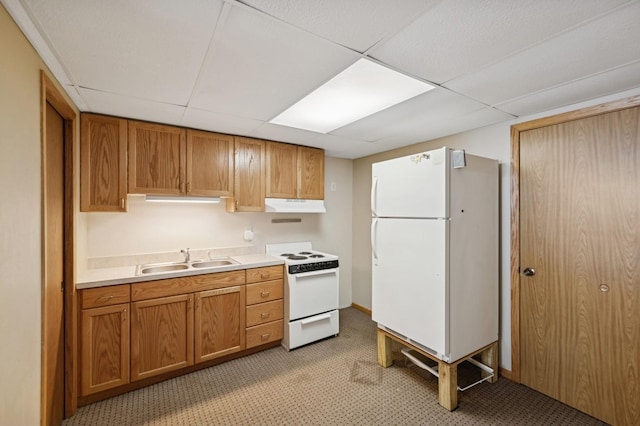 kitchen with light countertops, brown cabinetry, a sink, white appliances, and under cabinet range hood