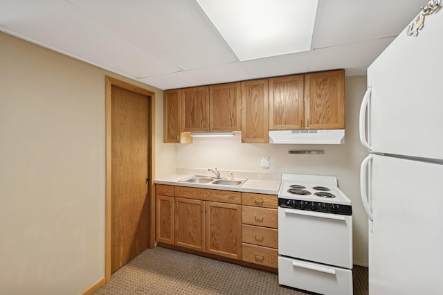 kitchen featuring brown cabinets, light countertops, a sink, white appliances, and under cabinet range hood