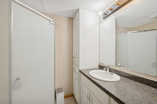 full bath with visible vents, a stall shower, a drop ceiling, and vanity