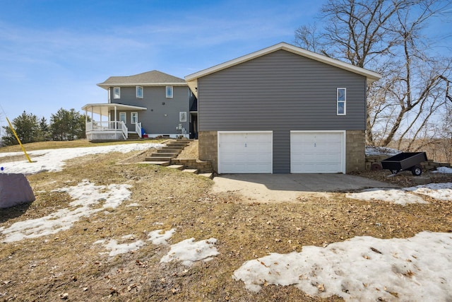 rear view of house featuring stairway and an attached garage