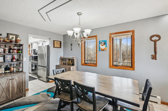 dining room with a notable chandelier, light tile patterned flooring, a baseboard radiator, and a textured ceiling