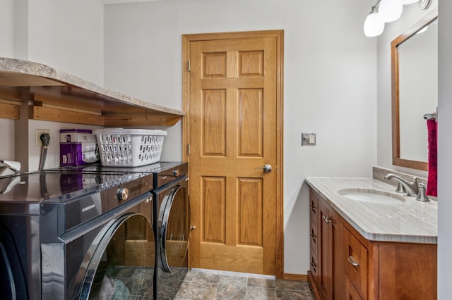 clothes washing area featuring washer and dryer, bar, and a sink