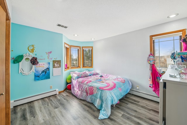 bedroom featuring visible vents, multiple windows, and a baseboard radiator