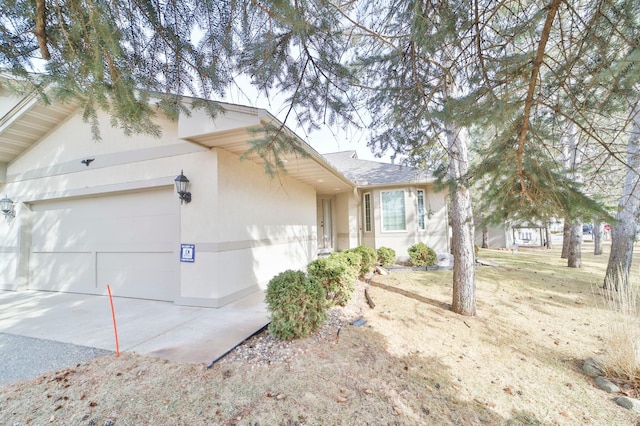 single story home featuring concrete driveway, a garage, and stucco siding