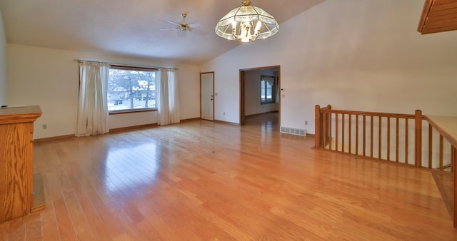 unfurnished room with visible vents, baseboards, vaulted ceiling, an inviting chandelier, and light wood-style floors