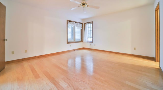 empty room with ceiling fan, baseboards, and wood finished floors