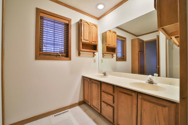 full bathroom with double vanity, ornamental molding, visible vents, and a sink