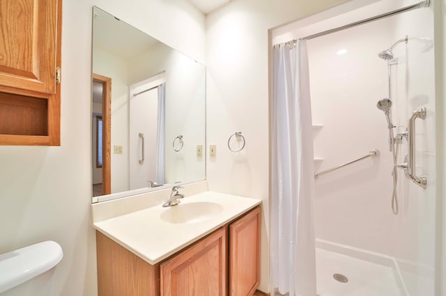 bathroom featuring toilet, a stall shower, and vanity