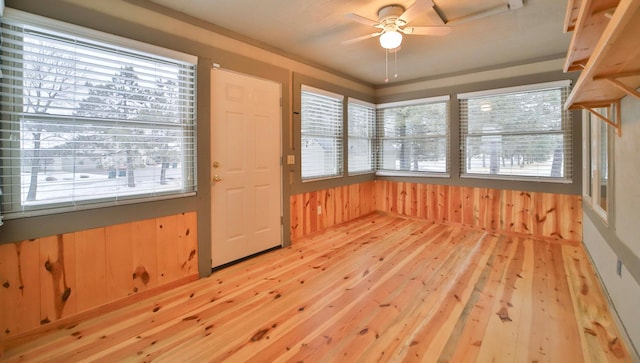 unfurnished sunroom featuring a healthy amount of sunlight and ceiling fan