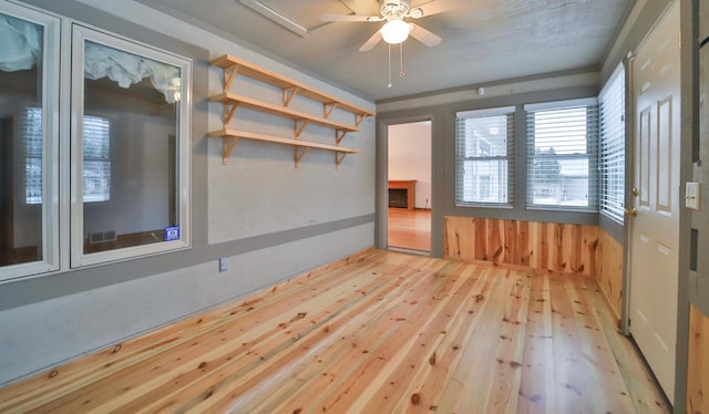 empty room featuring visible vents, a ceiling fan, and light wood-style floors