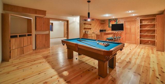 game room with billiards, light wood-style floors, wood walls, and a dry bar