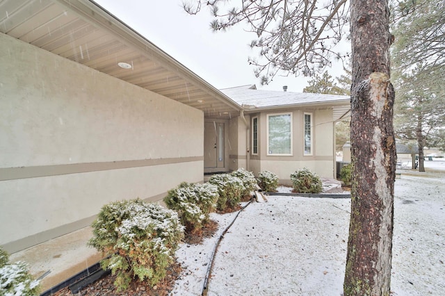 entrance to property featuring stucco siding