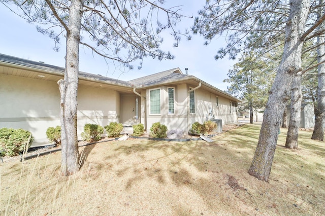 view of front facade with stucco siding and a front lawn