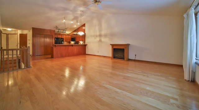 14686 Par Dr, Baxter, MN 56425 - unfurnished living room with baseboards, light wood-type flooring, vaulted ceiling, a fireplace, and a ceiling fan