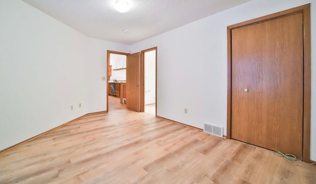 14686 Par Dr, Baxter, MN 56425 - unfurnished bedroom with light wood finished floors, a closet, visible vents, and a textured ceiling