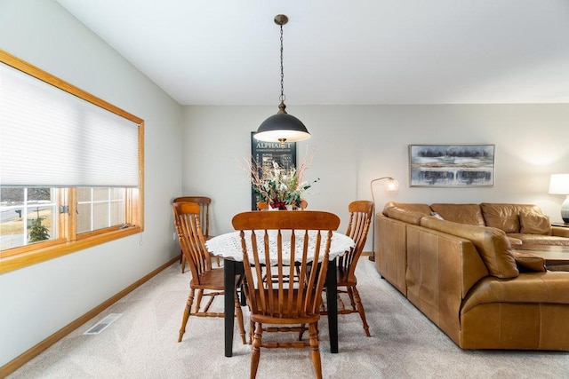 dining space featuring baseboards, light carpet, and visible vents
