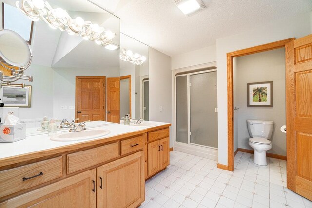 full bathroom with a sink, a stall shower, toilet, and double vanity