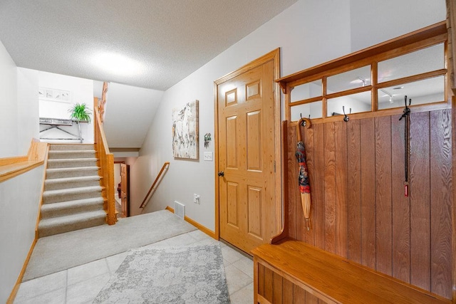 mudroom with tile patterned floors, baseboards, and a textured ceiling