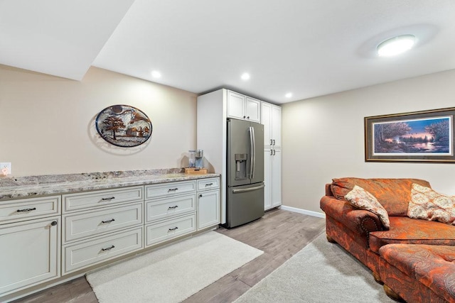 living room with recessed lighting, baseboards, and light wood-style floors