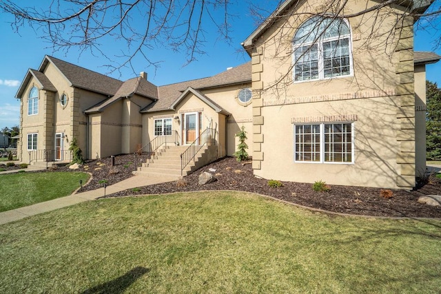 traditional home with a shingled roof, a front lawn, and stucco siding