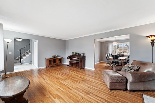 living room with light wood-style flooring, stairway, and baseboards