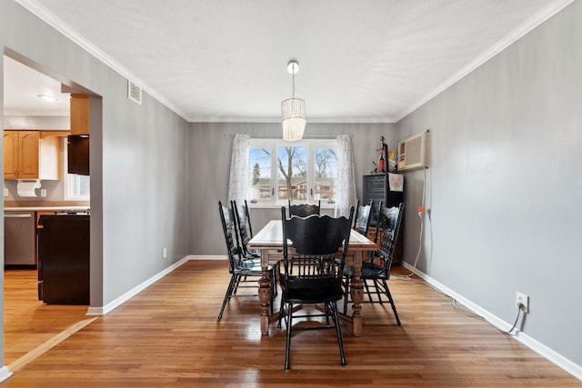 dining area featuring light wood-style flooring, baseboards, crown molding, and a wall mounted AC