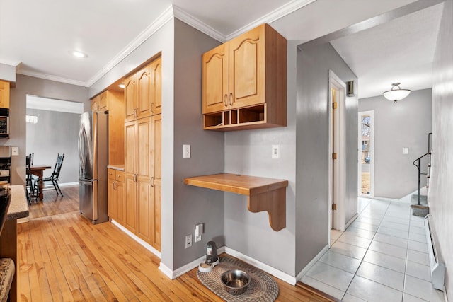 corridor featuring light wood-style floors, crown molding, and baseboards