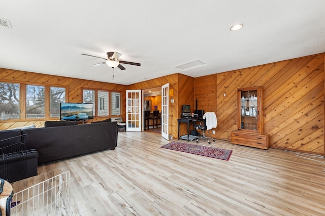 living area featuring attic access, visible vents, wood finished floors, and french doors